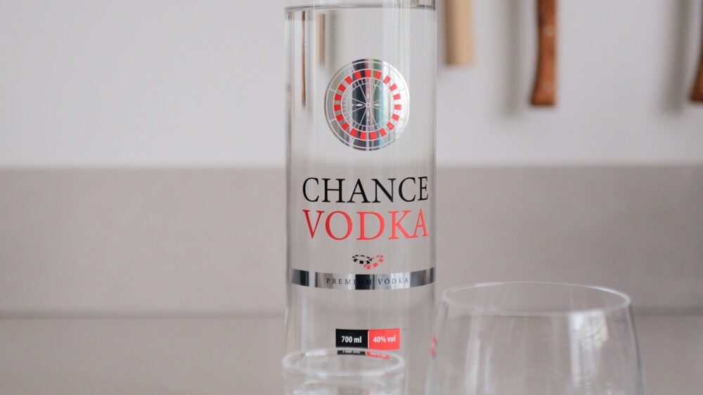 Fles Chance Vodka op een tafel met een glas op ijs ernaast