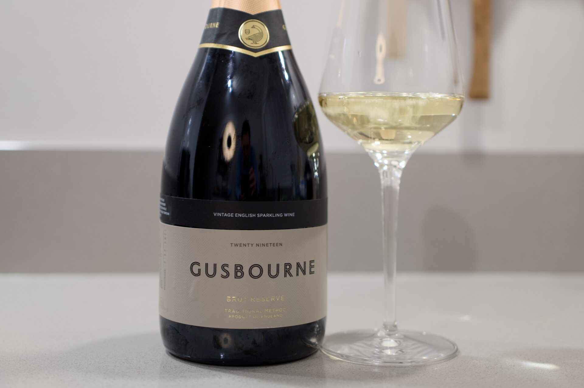 Gusbourne Brut Reserve 2019 fles naast glas mousserende wijn