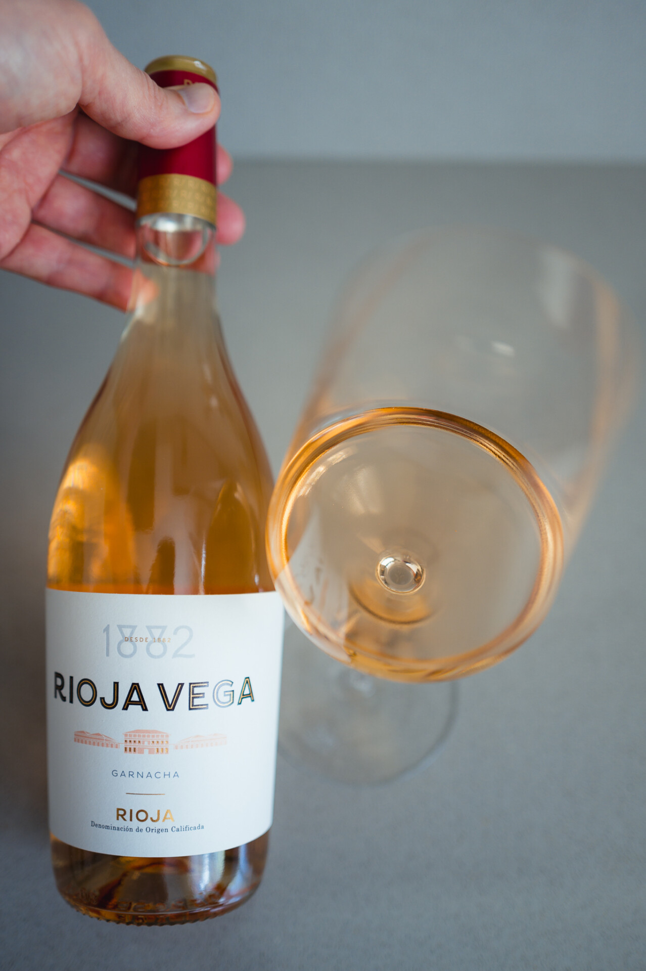 Fles Rioja Vega 1882 Rosado naast een glas zalmkleurige Spaanse rosé